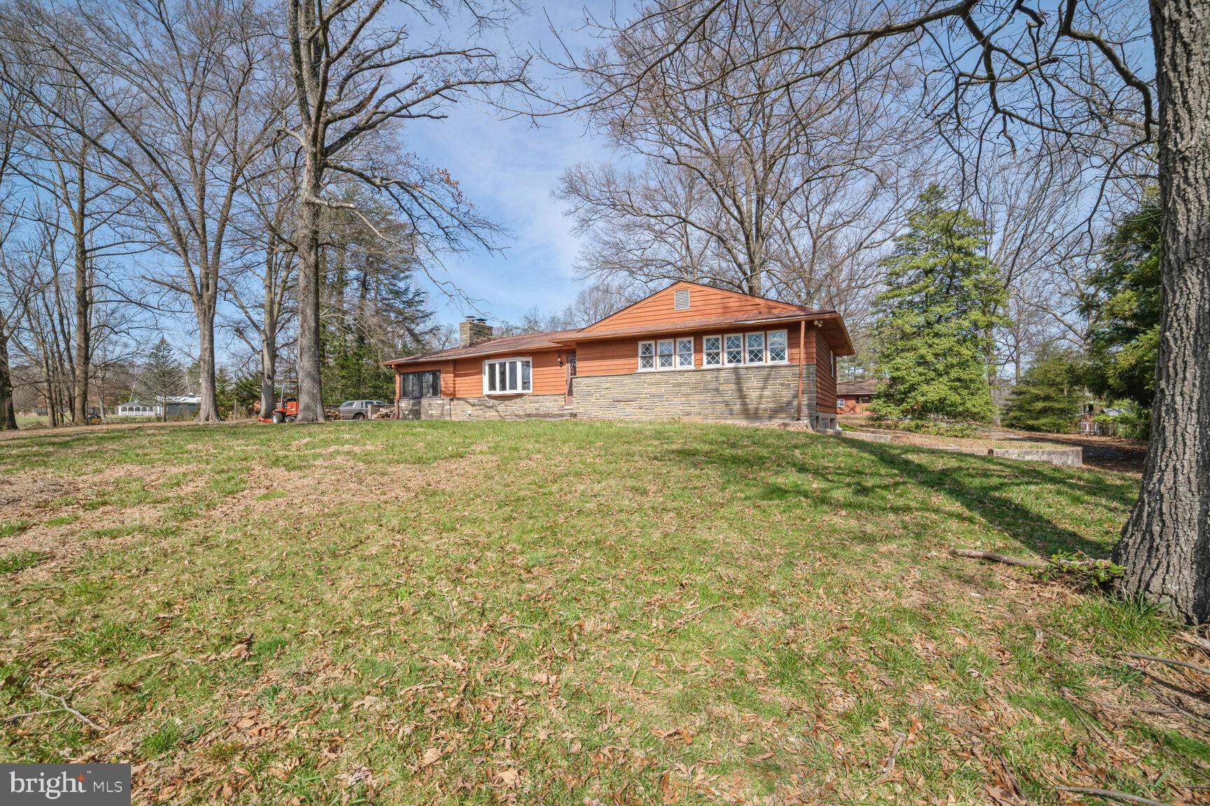 a large house with a big yard and large trees