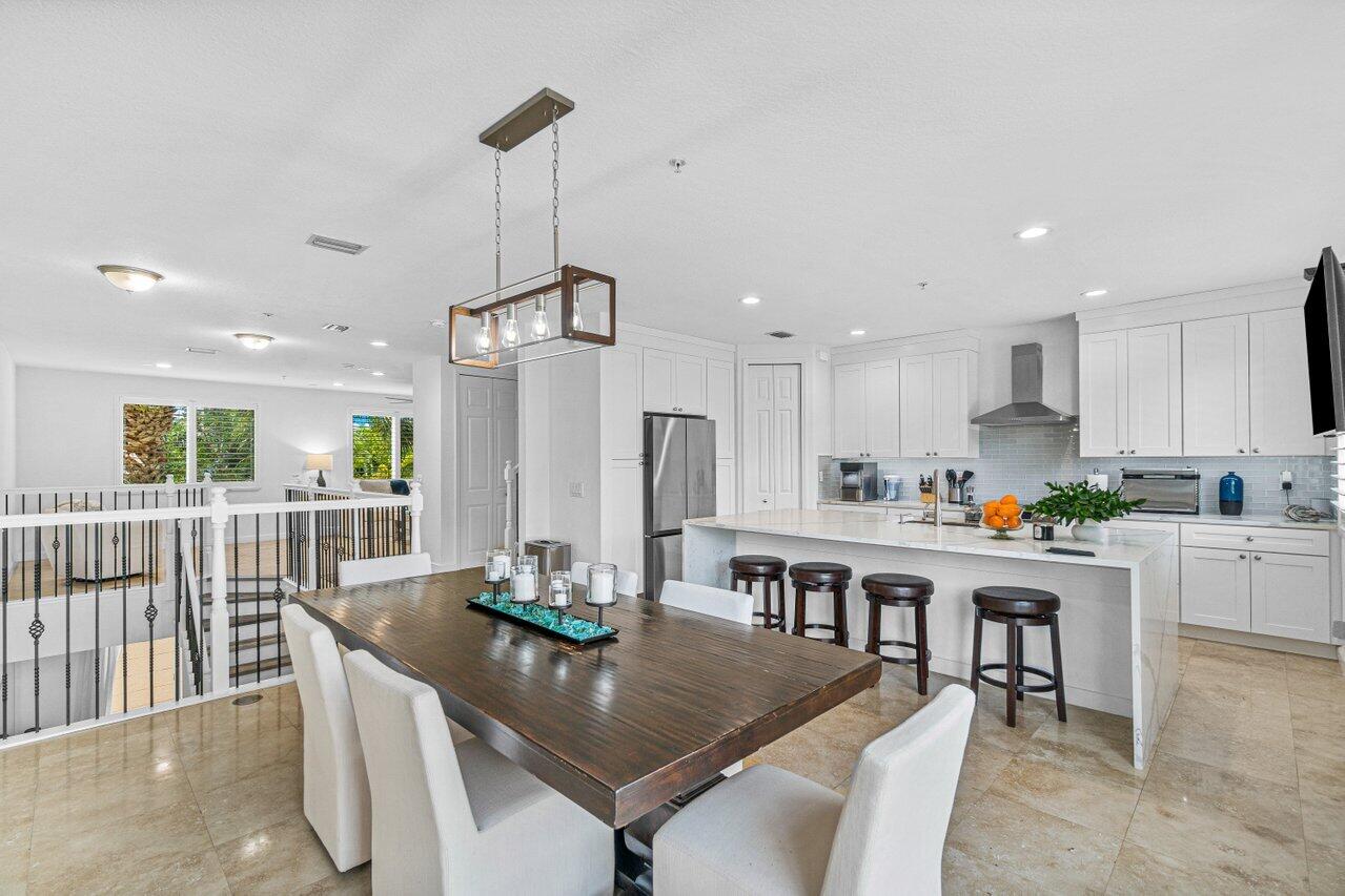 a kitchen with kitchen island a table and chairs in it