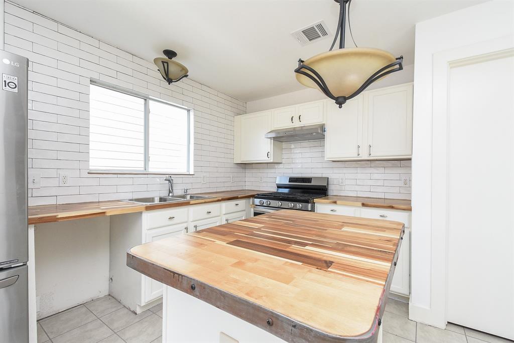 a kitchen with stainless steel appliances granite countertop a sink window and cabinets