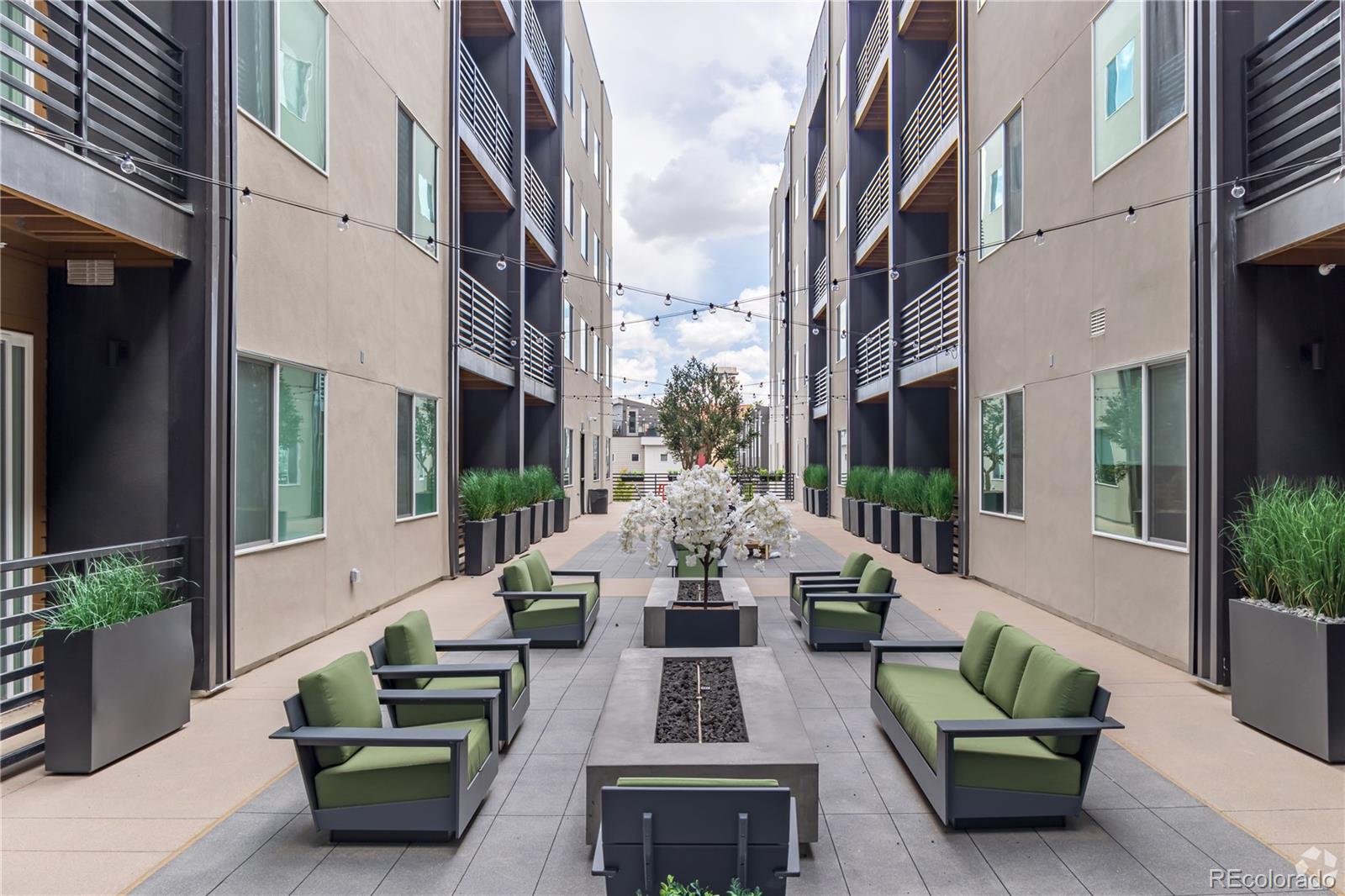 a view of a patio with couches table and chairs and potted plants