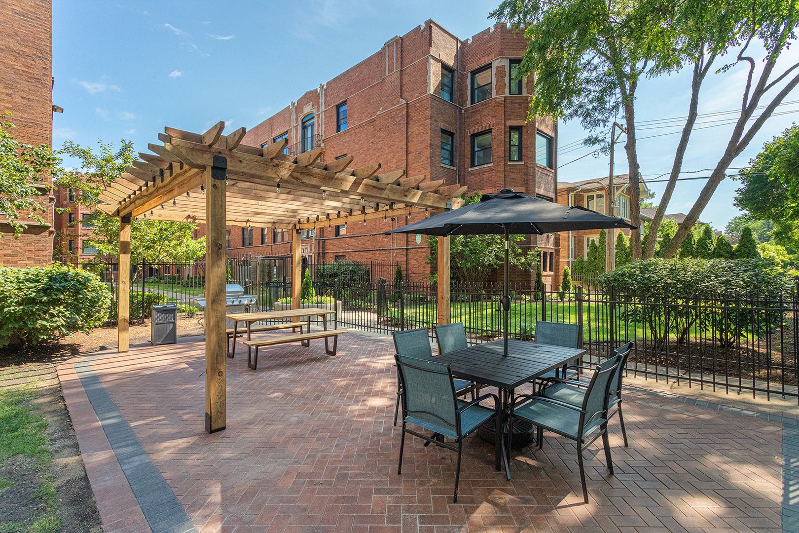 a view of a patio with a table and chairs under an umbrella with a fire pit