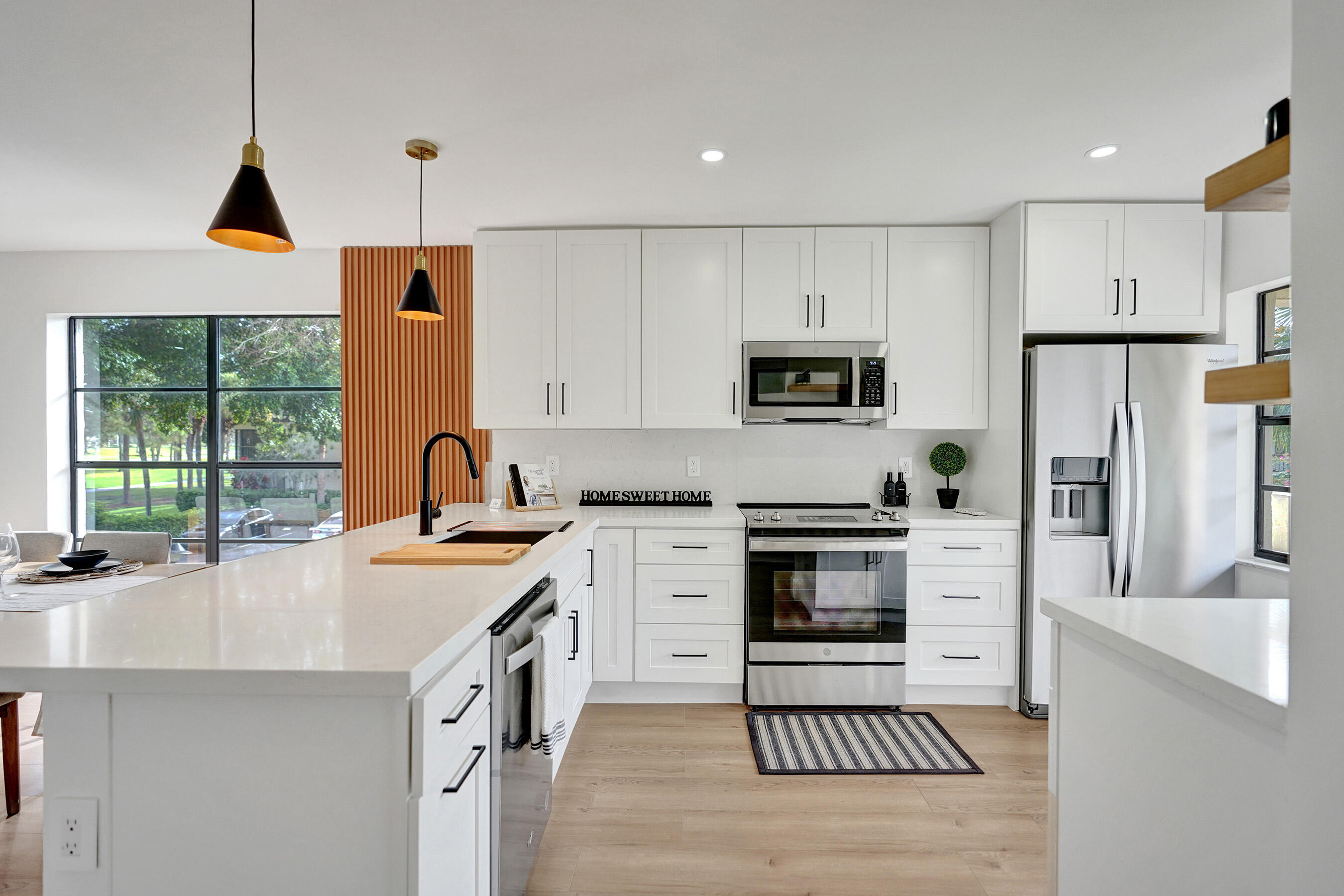 a kitchen with stainless steel appliances a stove a sink a refrigerator and a cabinets