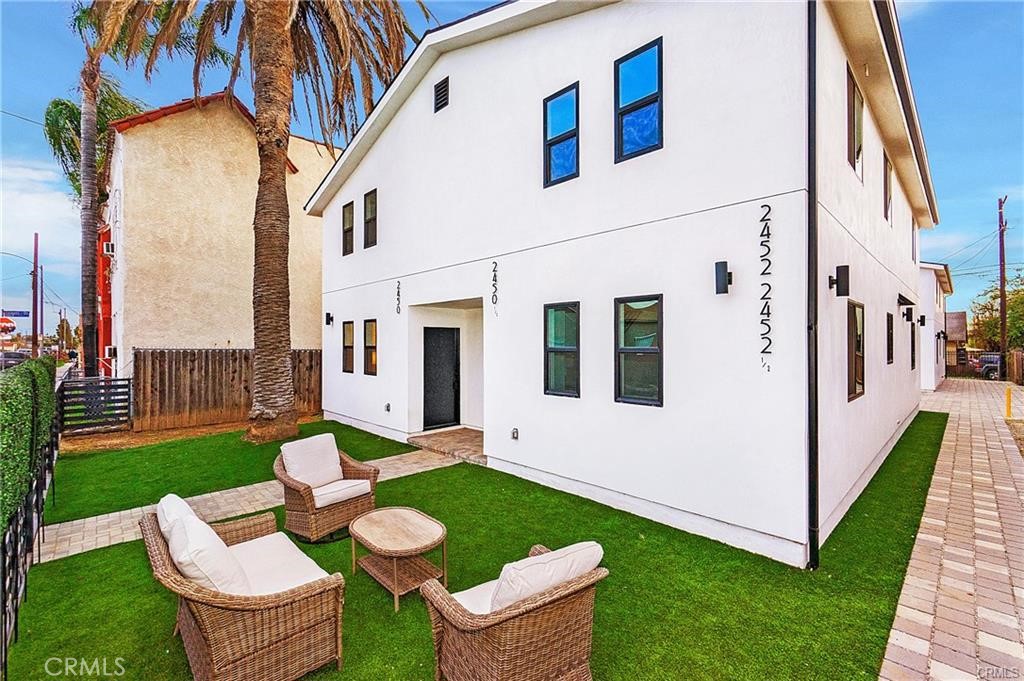 a view of a patio with couches chairs and a yard