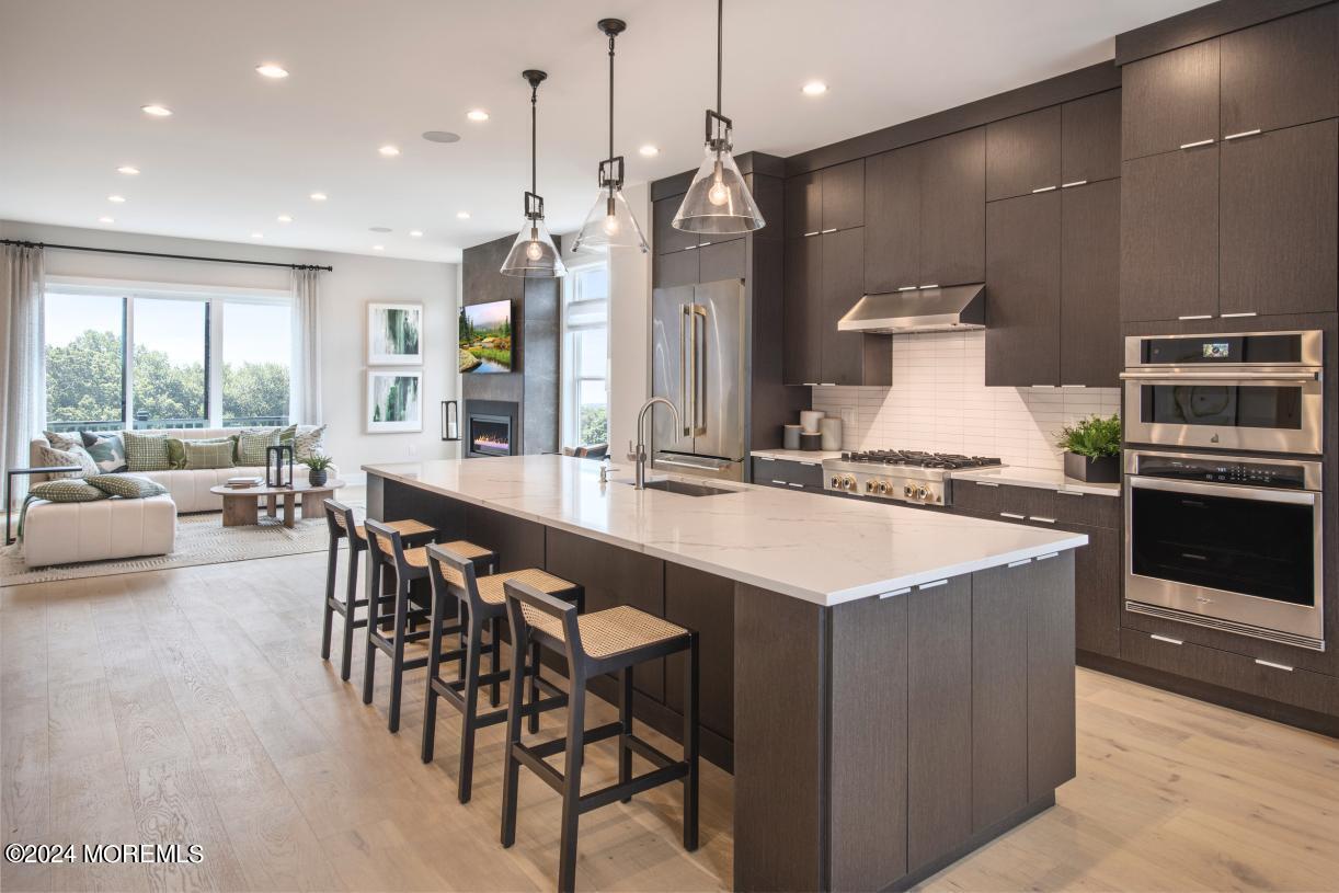 a open kitchen with stainless steel appliances kitchen island a large island in the center