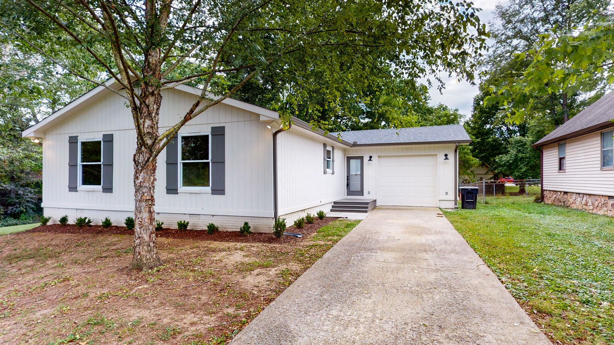 a view of a house with backyard and trees