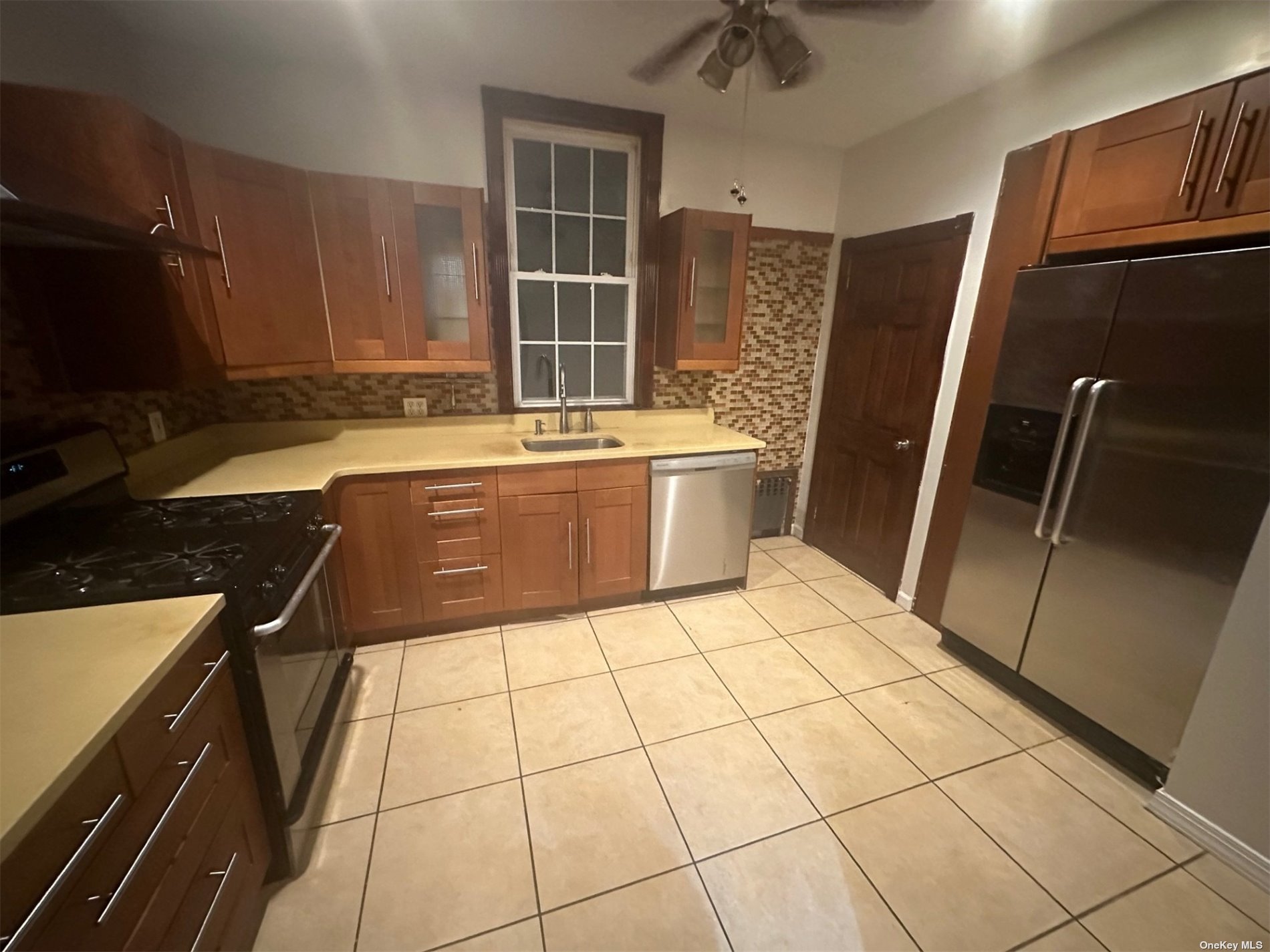 a kitchen with a sink a stove top oven a counter space and cabinets