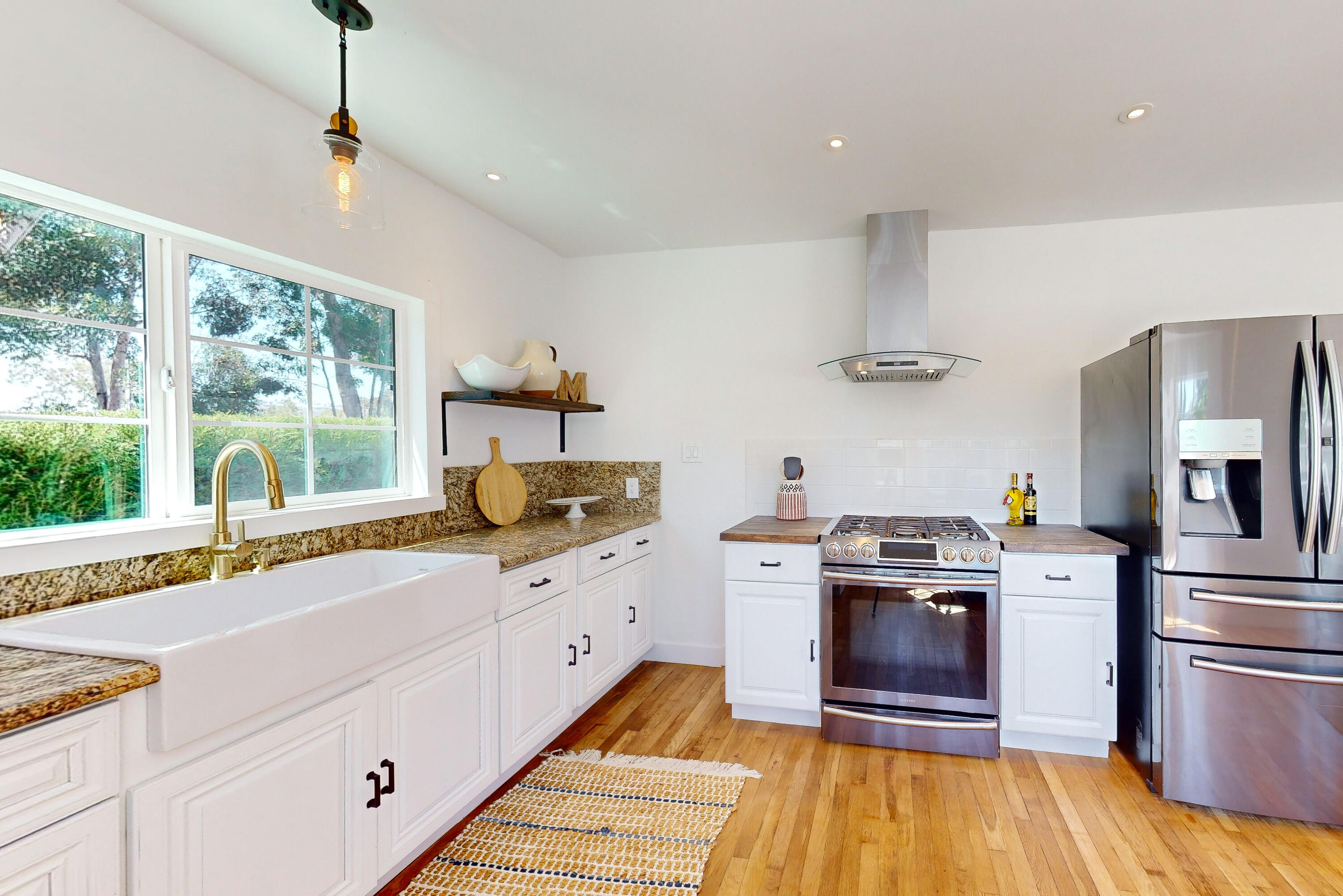 a kitchen with stainless steel appliances granite countertop a stove a sink and a refrigerator