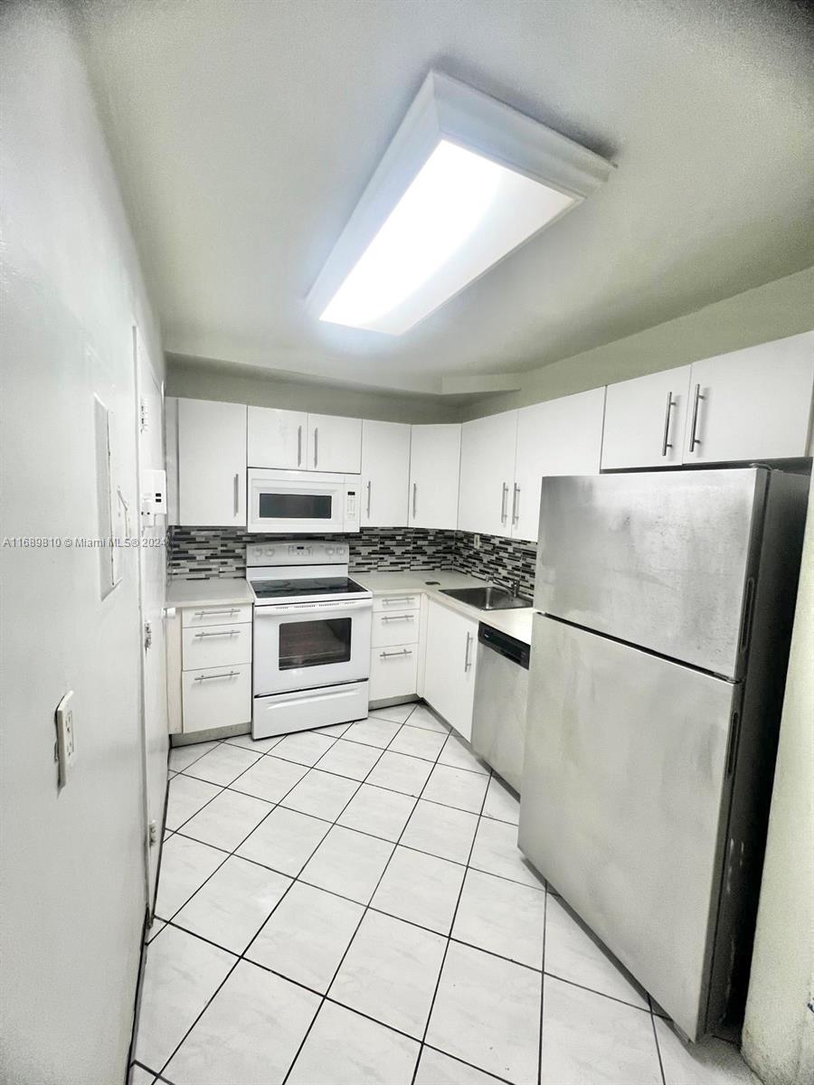 a white refrigerator freezer and a stove in a kitchen