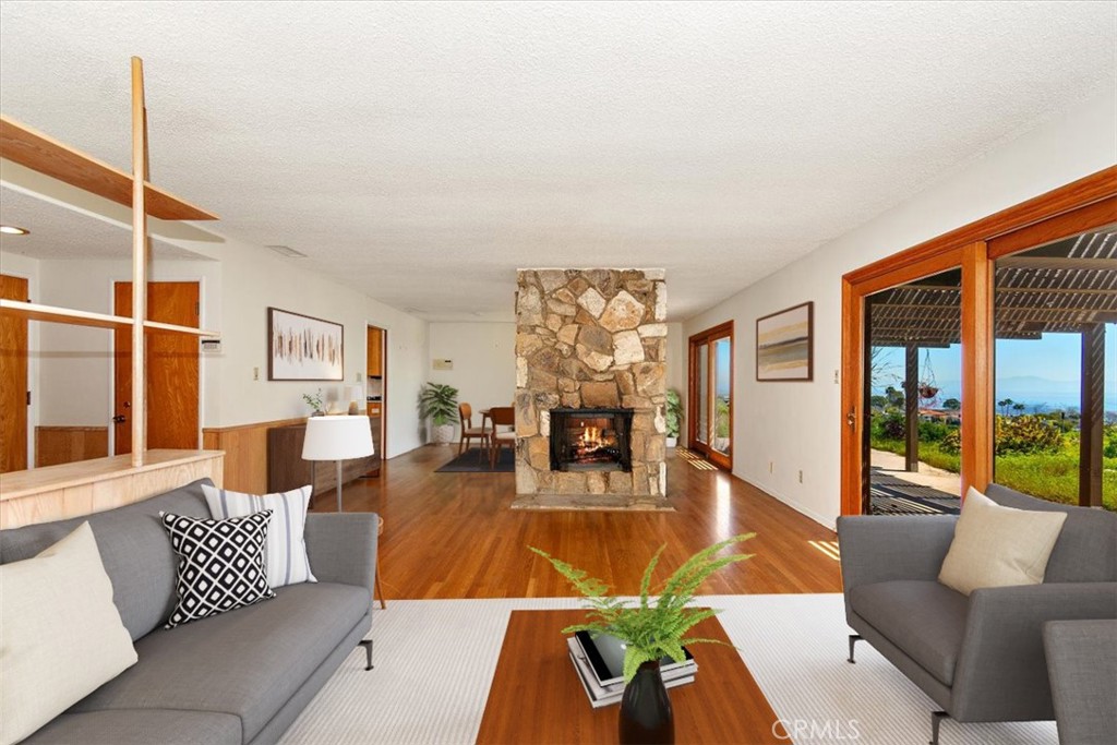 a living room with furniture kitchen view and large windows