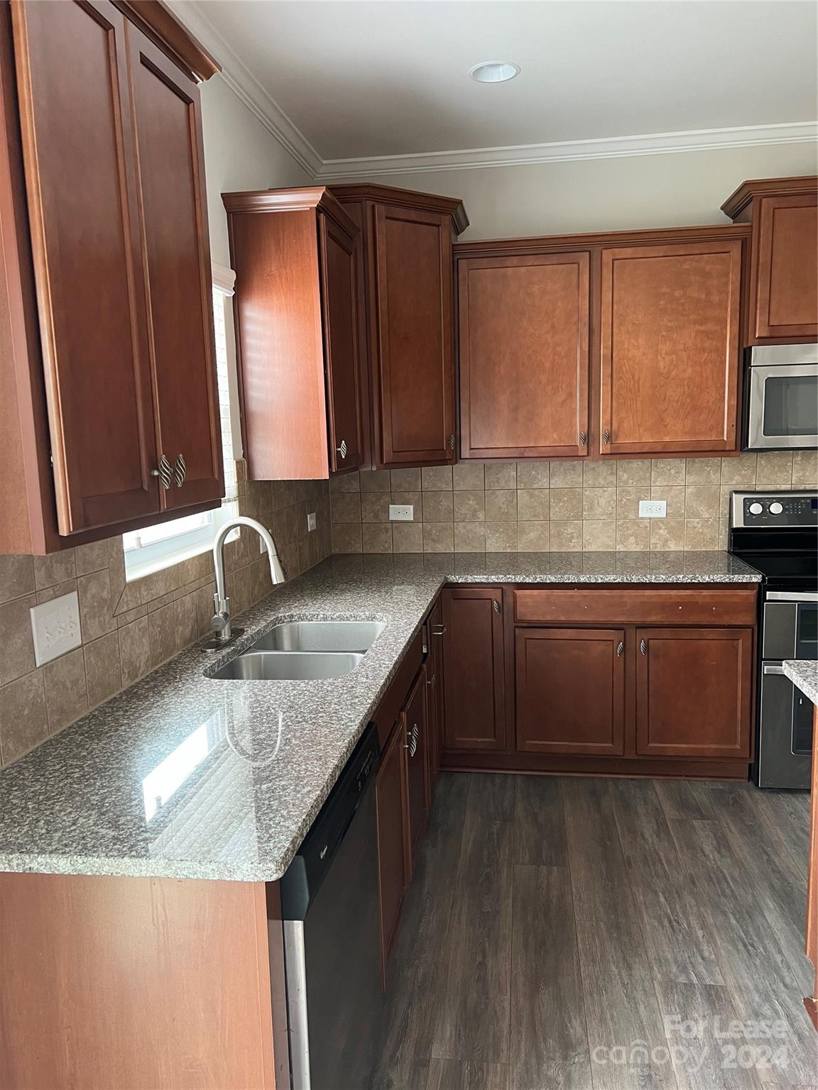 a kitchen with stainless steel appliances granite countertop a sink stove and cabinets