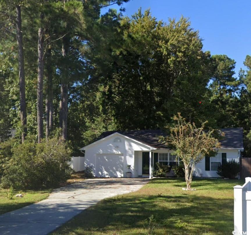 View of front of house with a garage and a front y