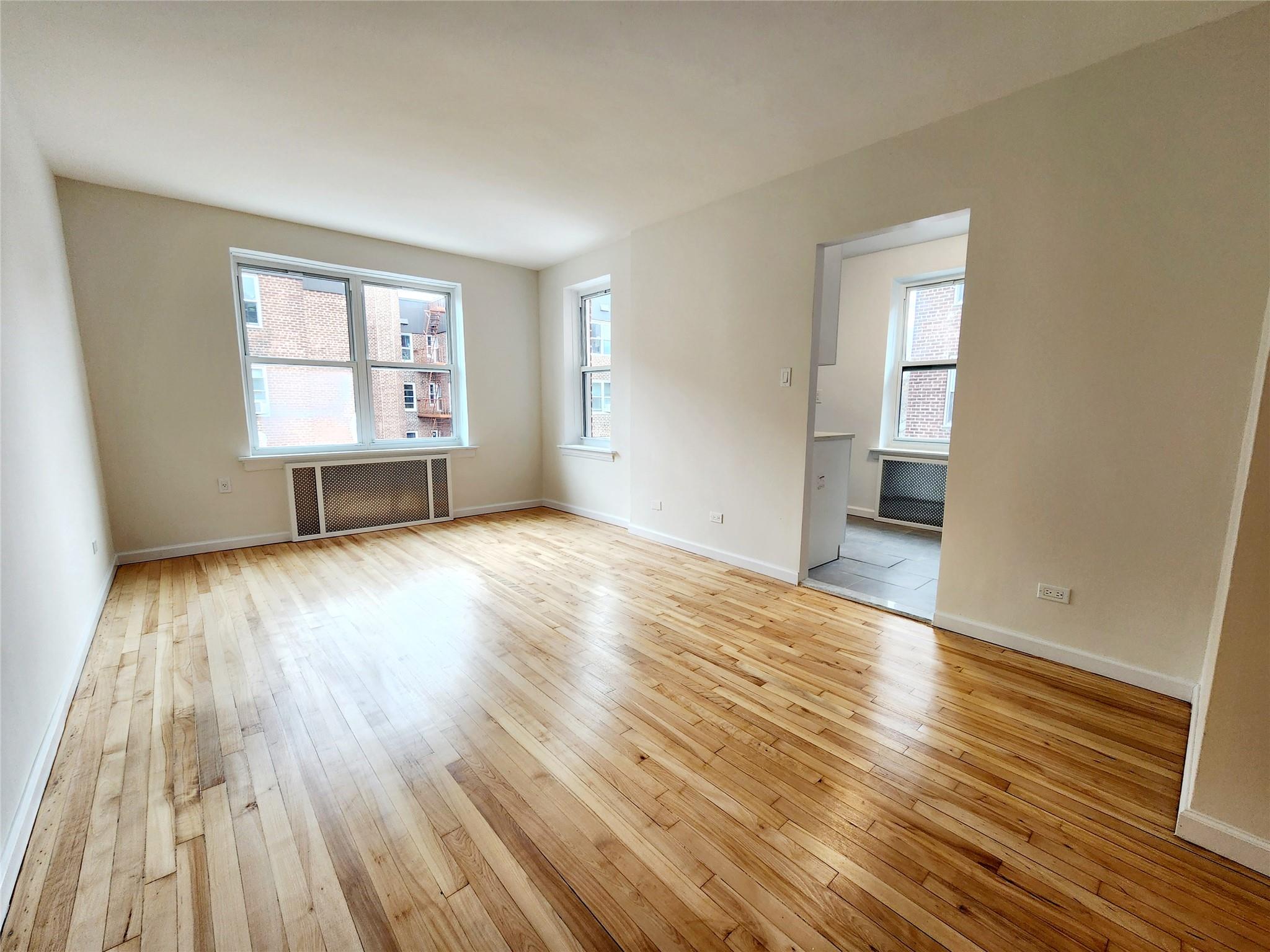 Spare room with radiator heating unit and light wood-type flooring