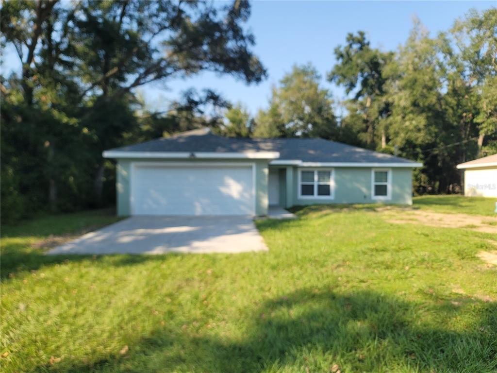 a front view of house with yard and trees