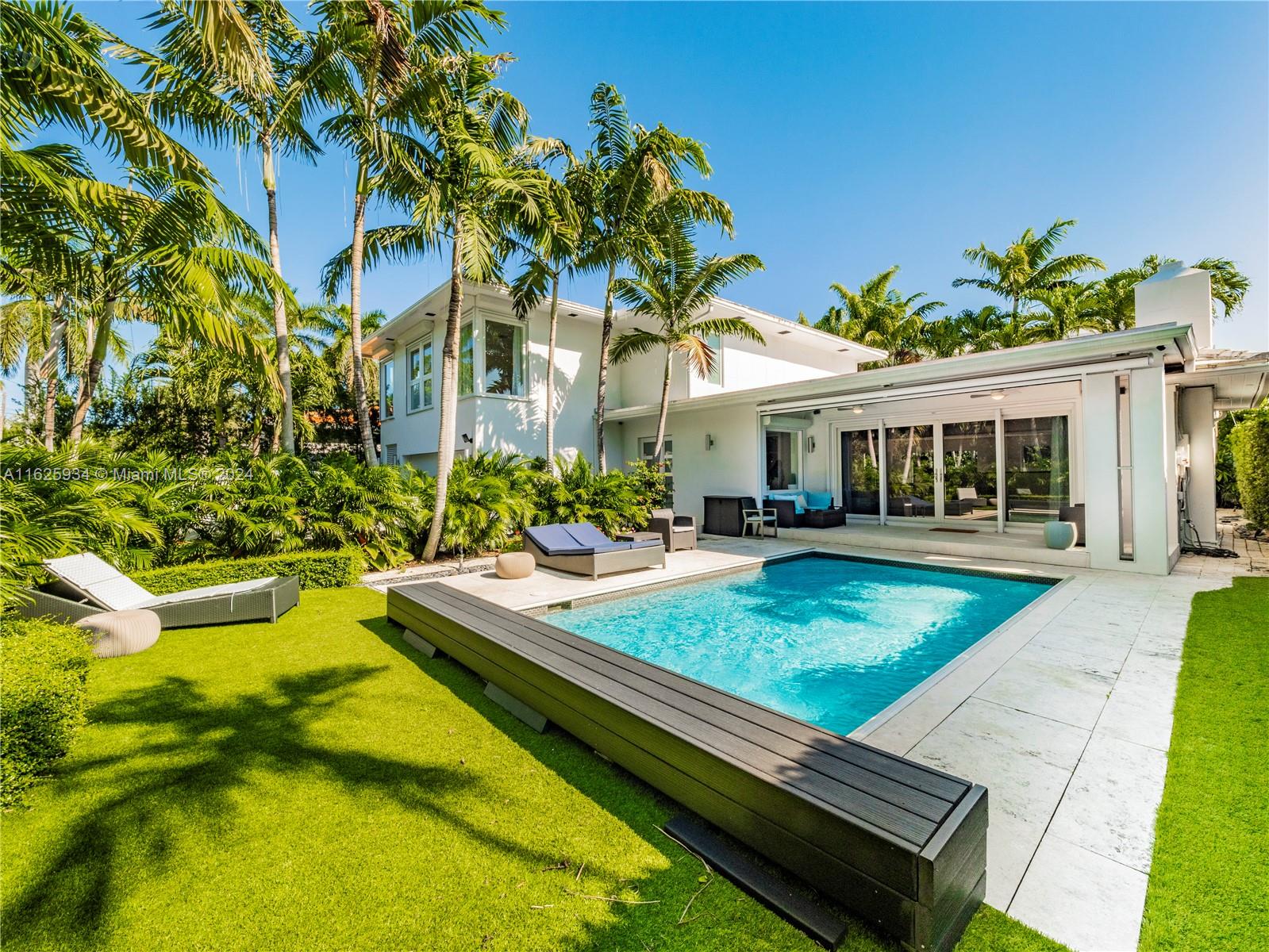 a view of a house with swimming pool and sitting area