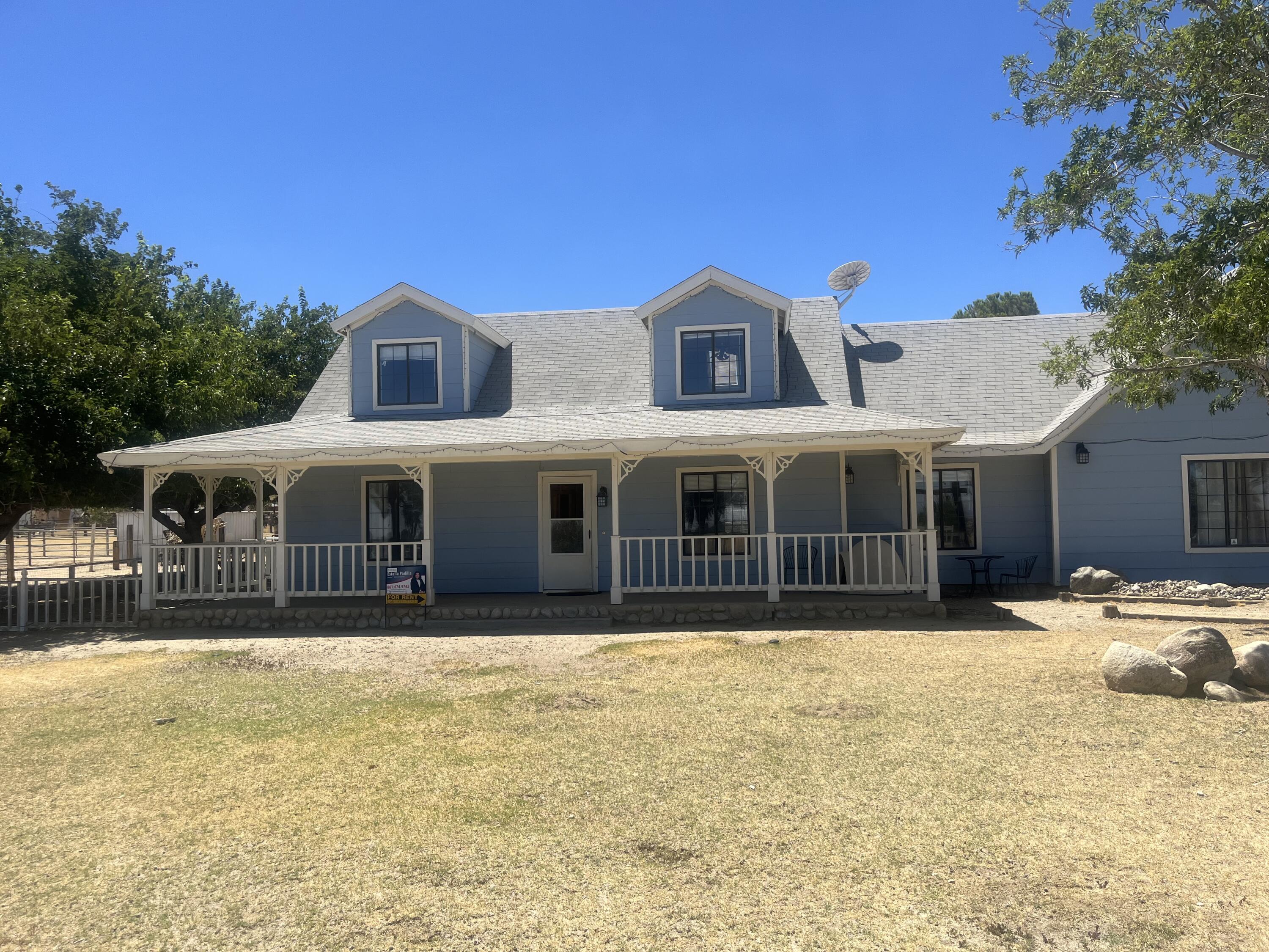 a front view of house with yard and trees in the background