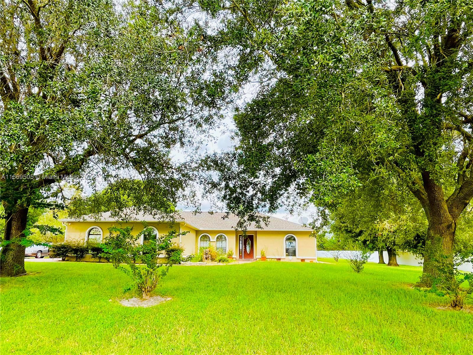 a front view of a house with a yard table and trees