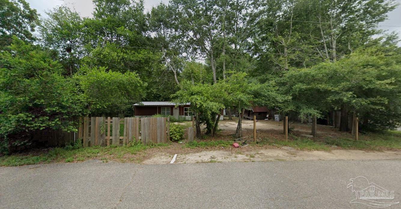 a front view of a house with a yard and tree