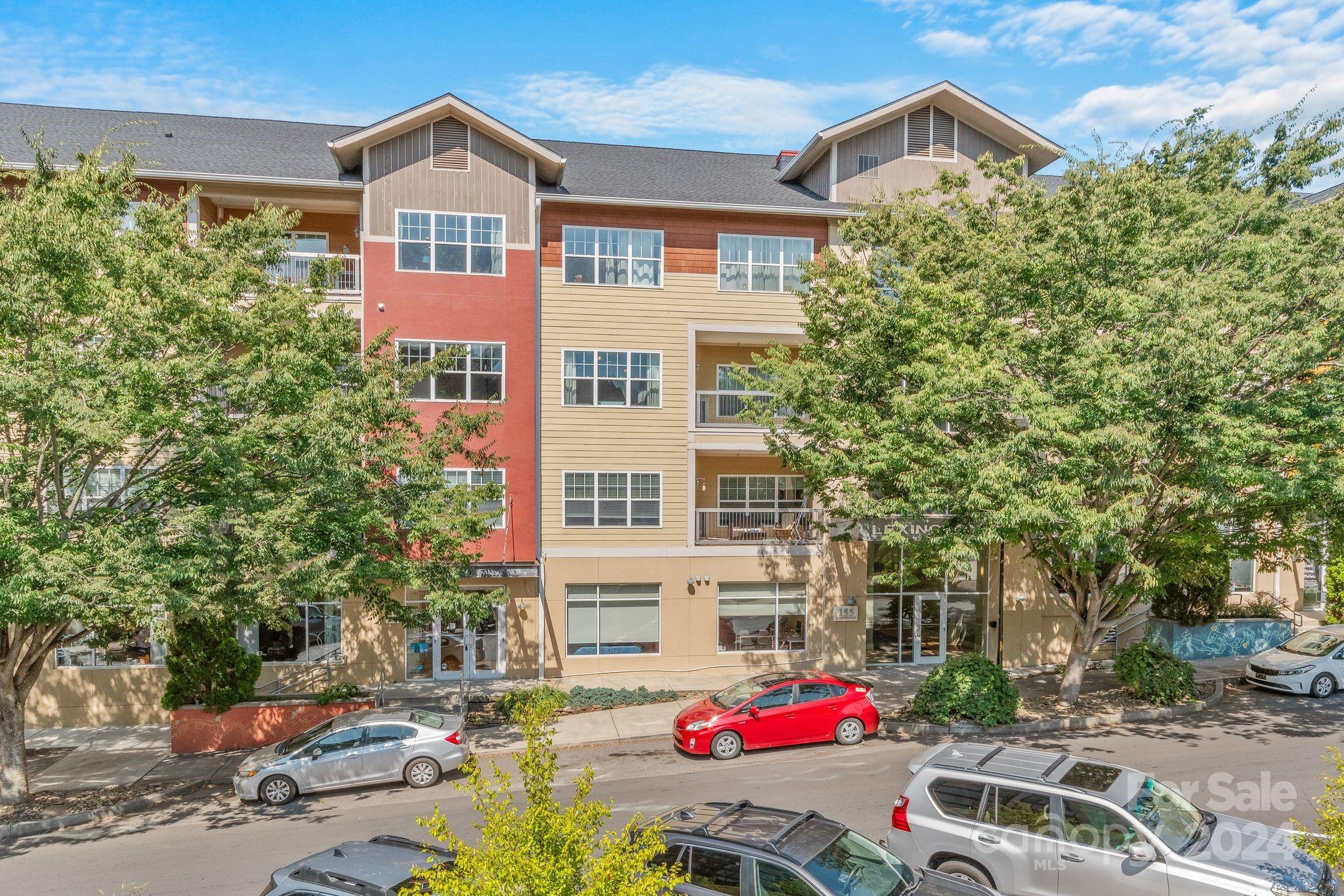 a front view of a building with lot of cars parked