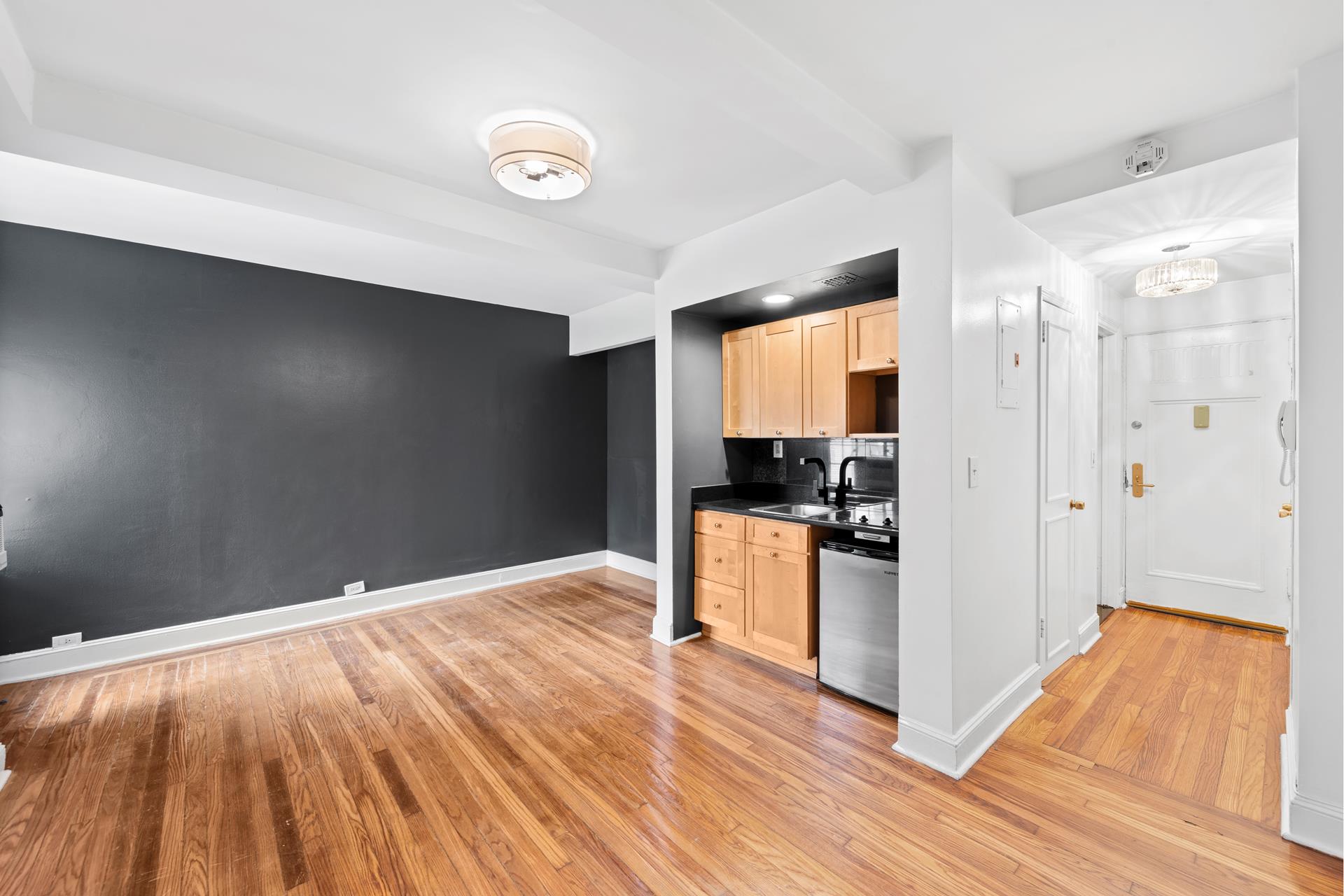 a kitchen with granite countertop a refrigerator and a stove top oven