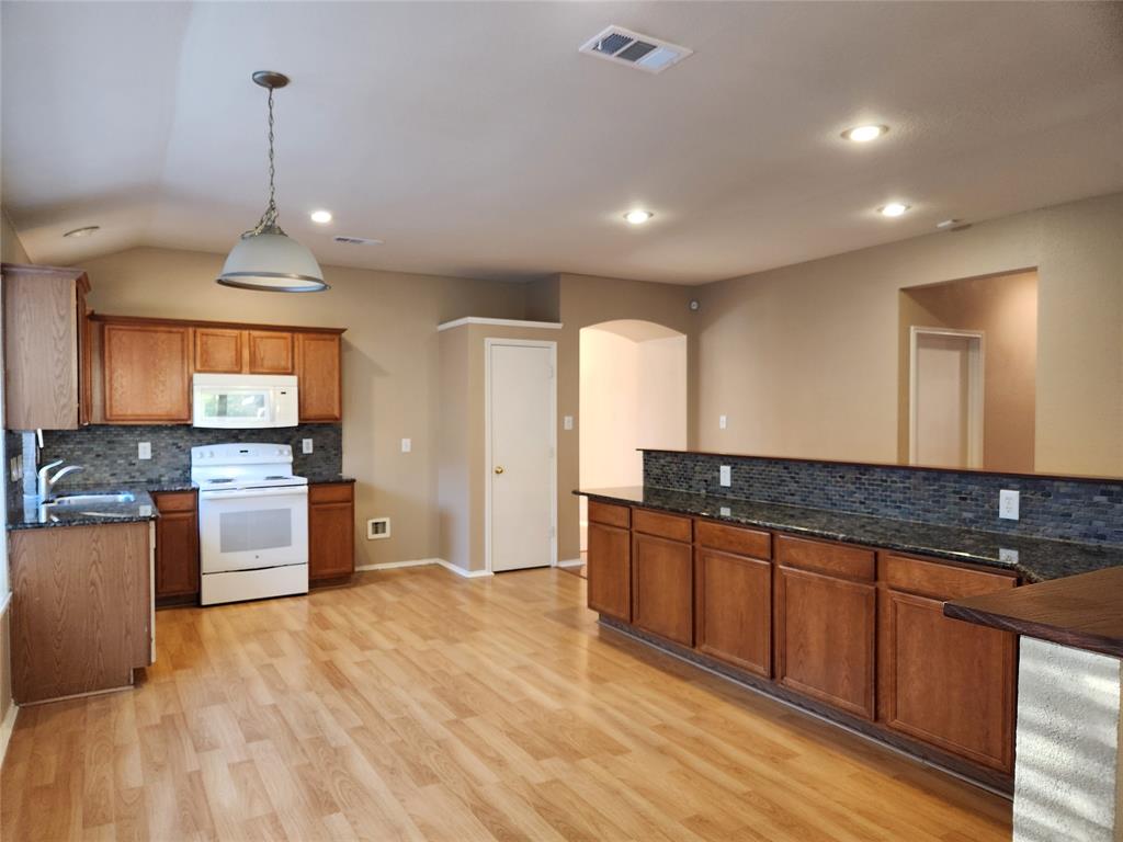 a large kitchen with stainless steel appliances granite countertop a sink and a stove