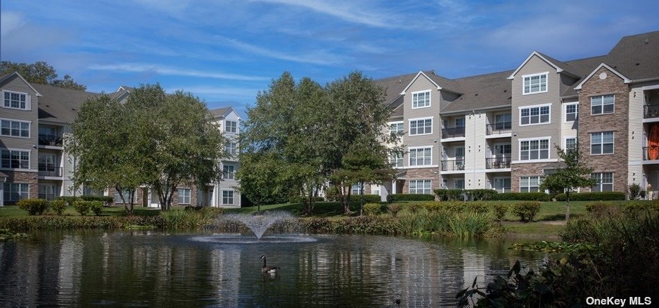 a front view of a house with a yard and lake view