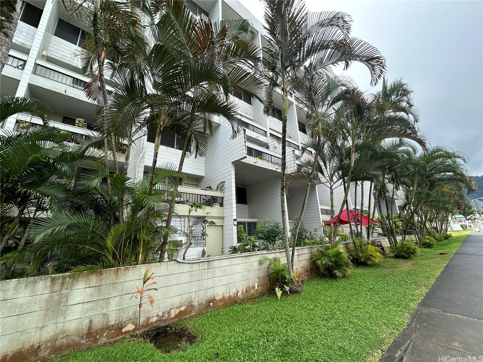 a front view of a house with a yard and potted plants