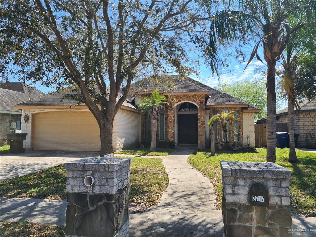 Ranch-style house featuring a garage and a front lawn