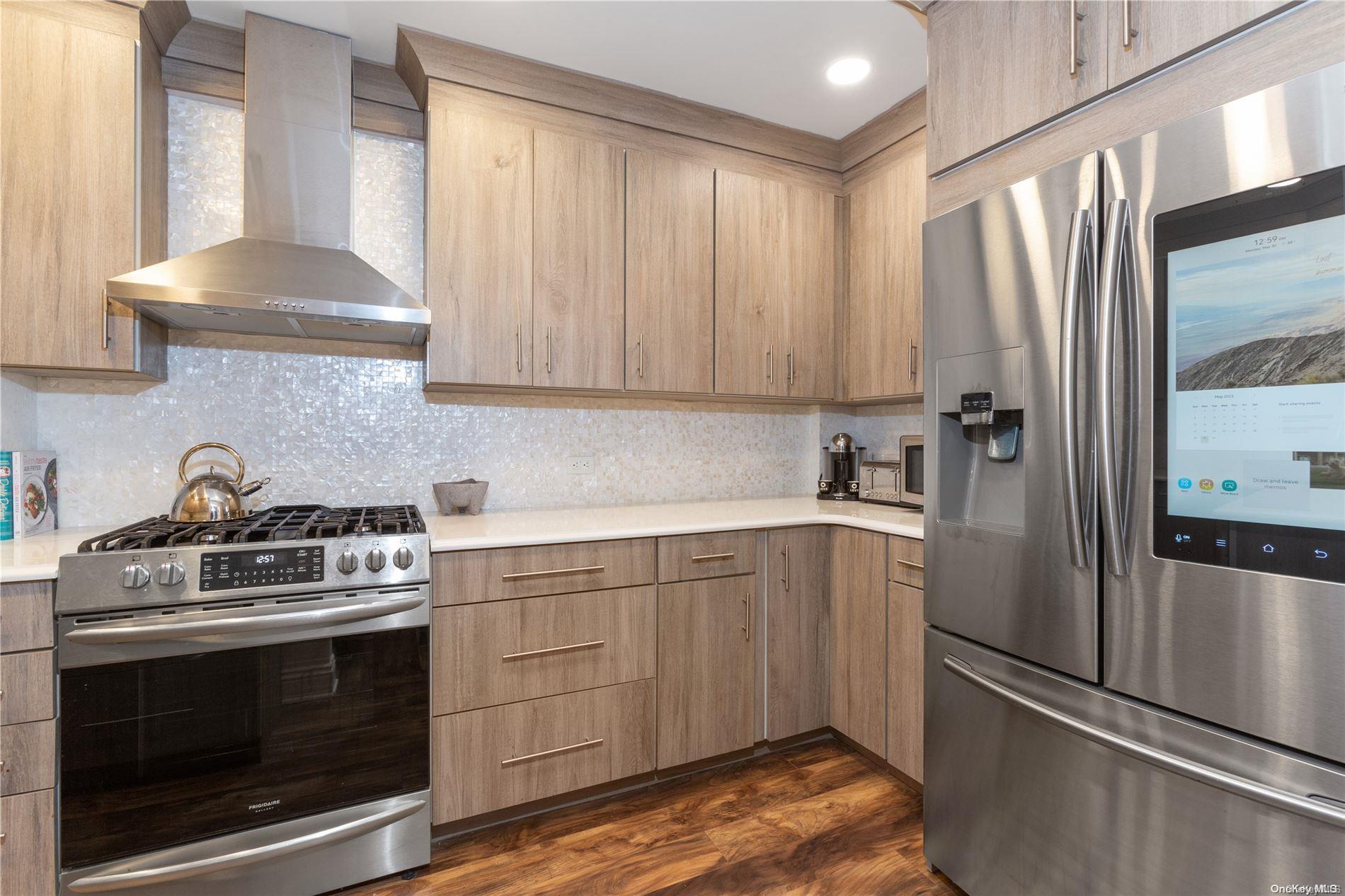 a kitchen with stainless steel appliances granite countertop a refrigerator sink and stove