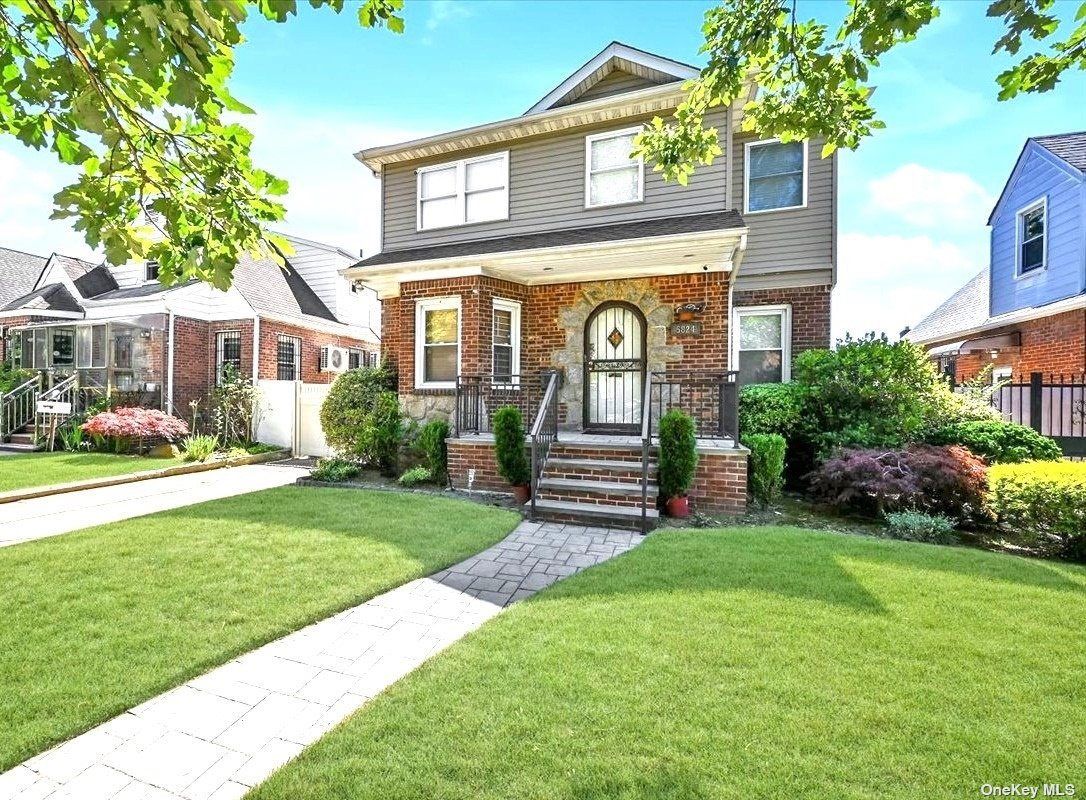 a front view of a house with a yard and trees