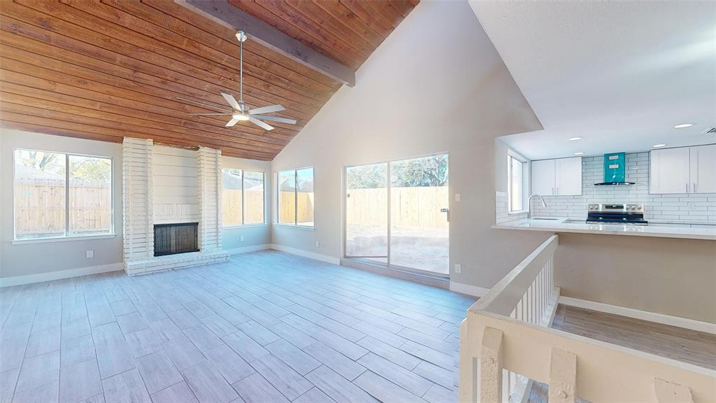 a view of empty room with wooden floor and fireplace