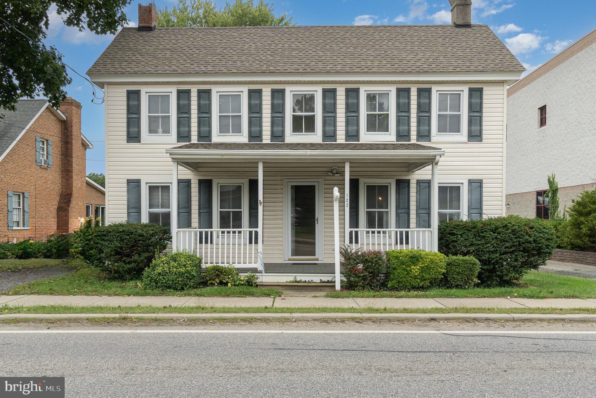 a front view of a house with a garden and plants