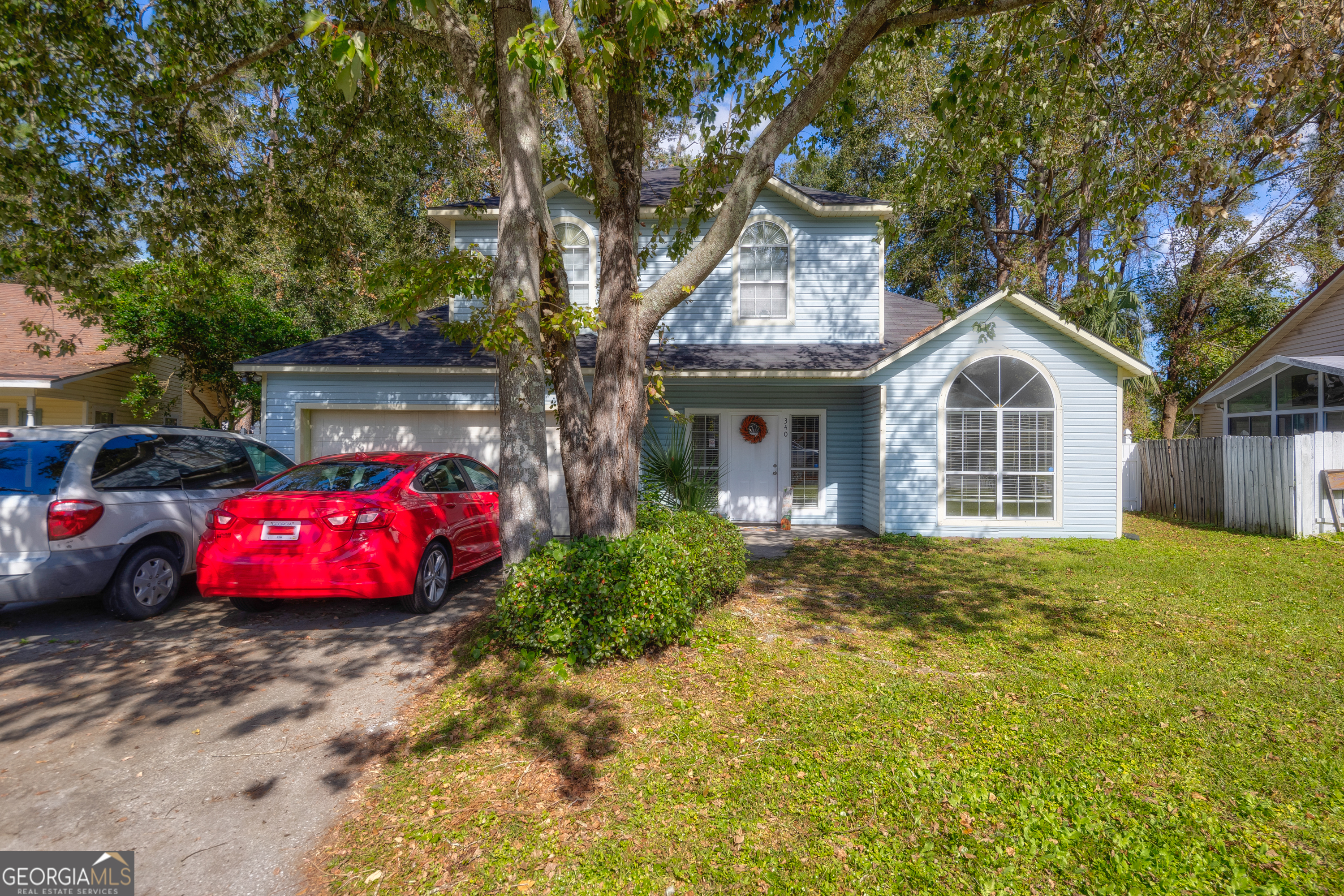 a front view of a house with cars parked