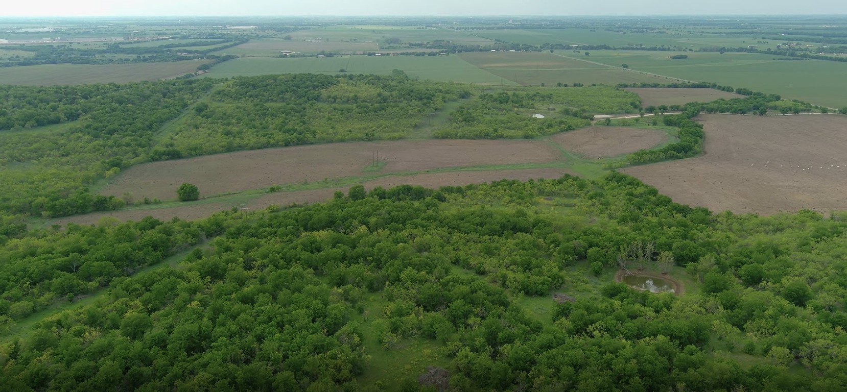 an aerial view of field with beach