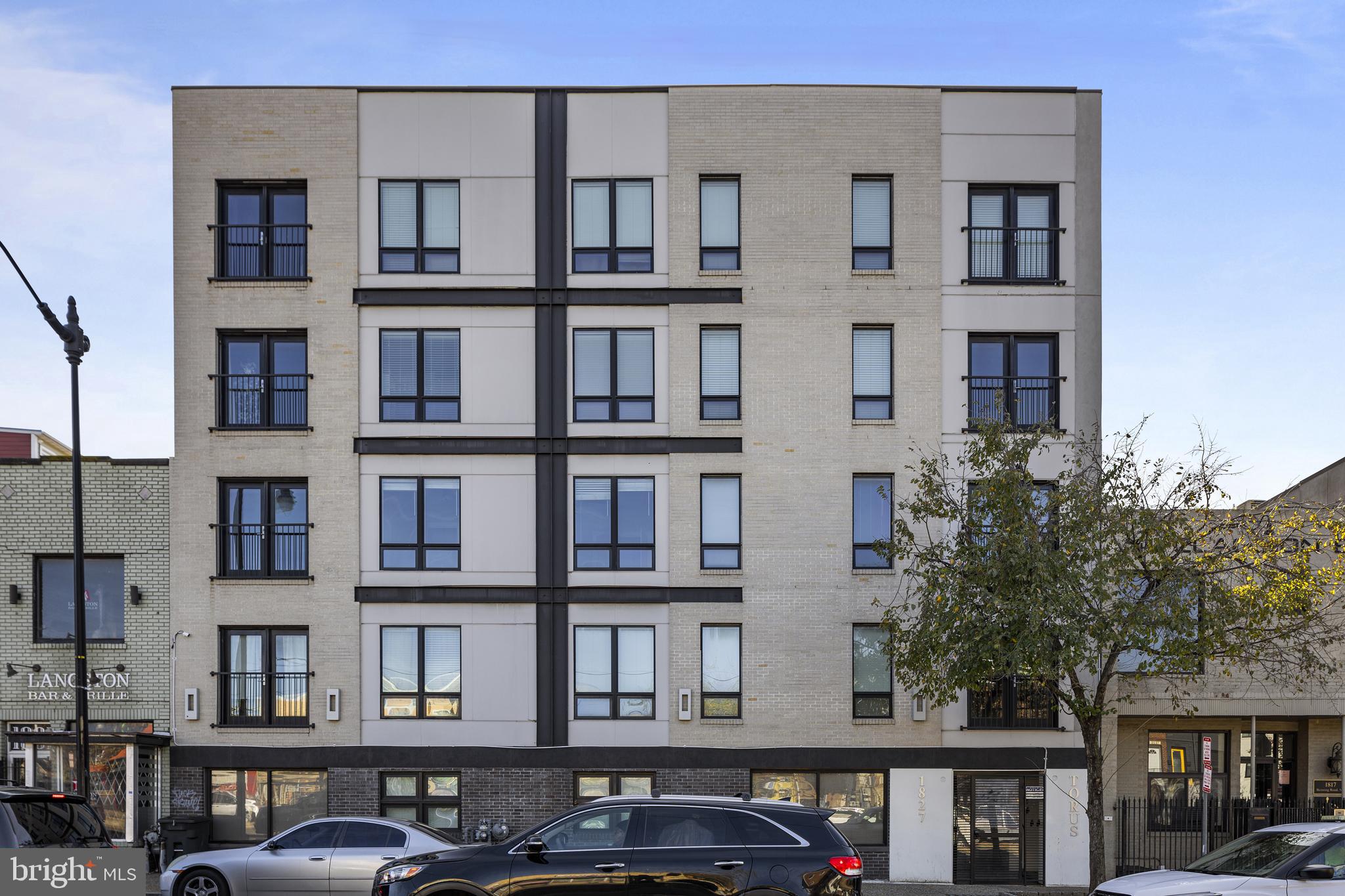 a front view of a residential apartment building with a yard