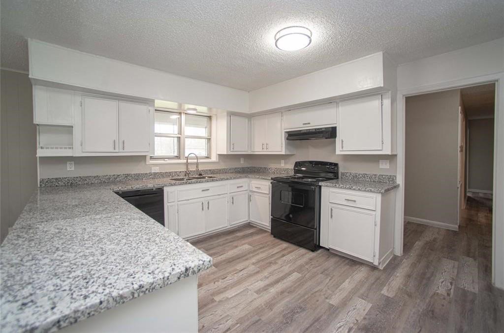 a kitchen with granite countertop a sink stainless steel appliances and cabinets