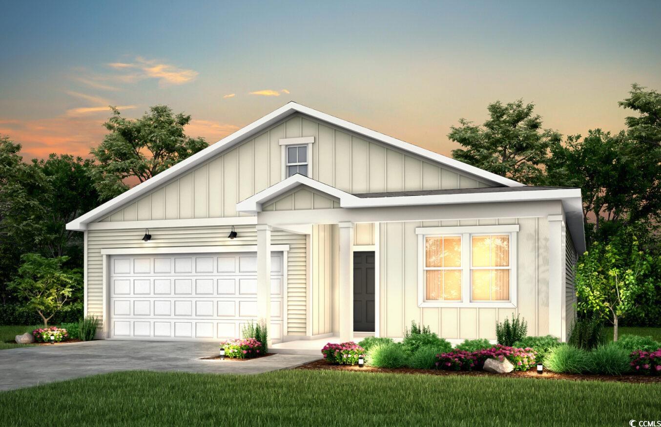 View of front of home with a garage and a lawn