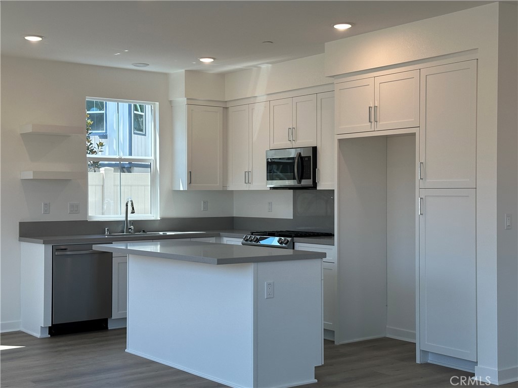 a kitchen with stainless steel appliances a sink stove and microwave