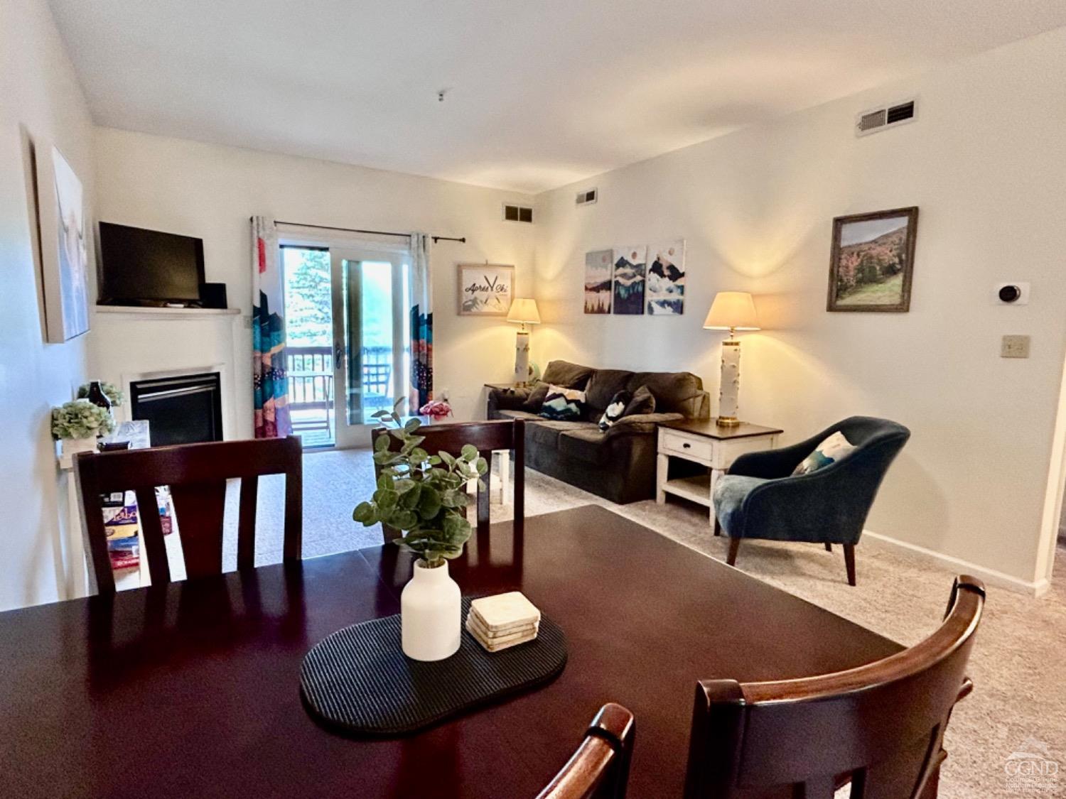 a living room with furniture a flat screen tv and kitchen view