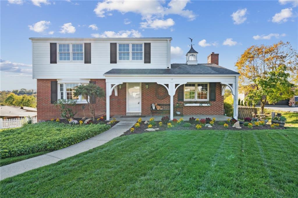 a front view of a house with a garden and plants