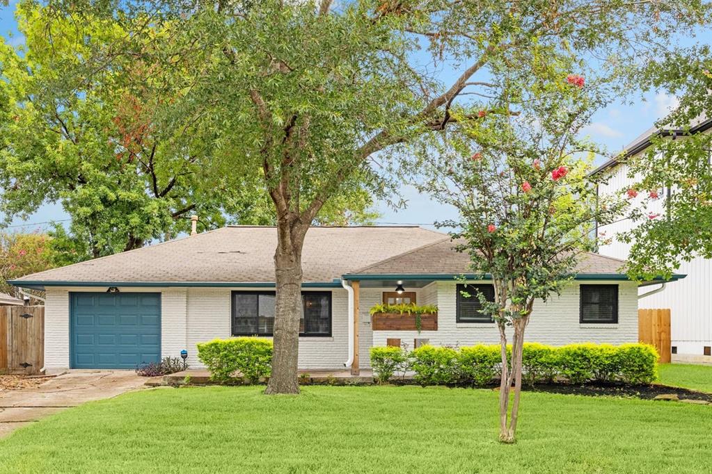 a front view of a house with a yard and trees