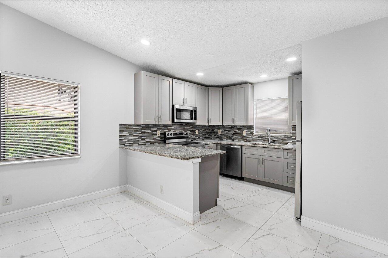 a kitchen with a refrigerator sink and cabinets