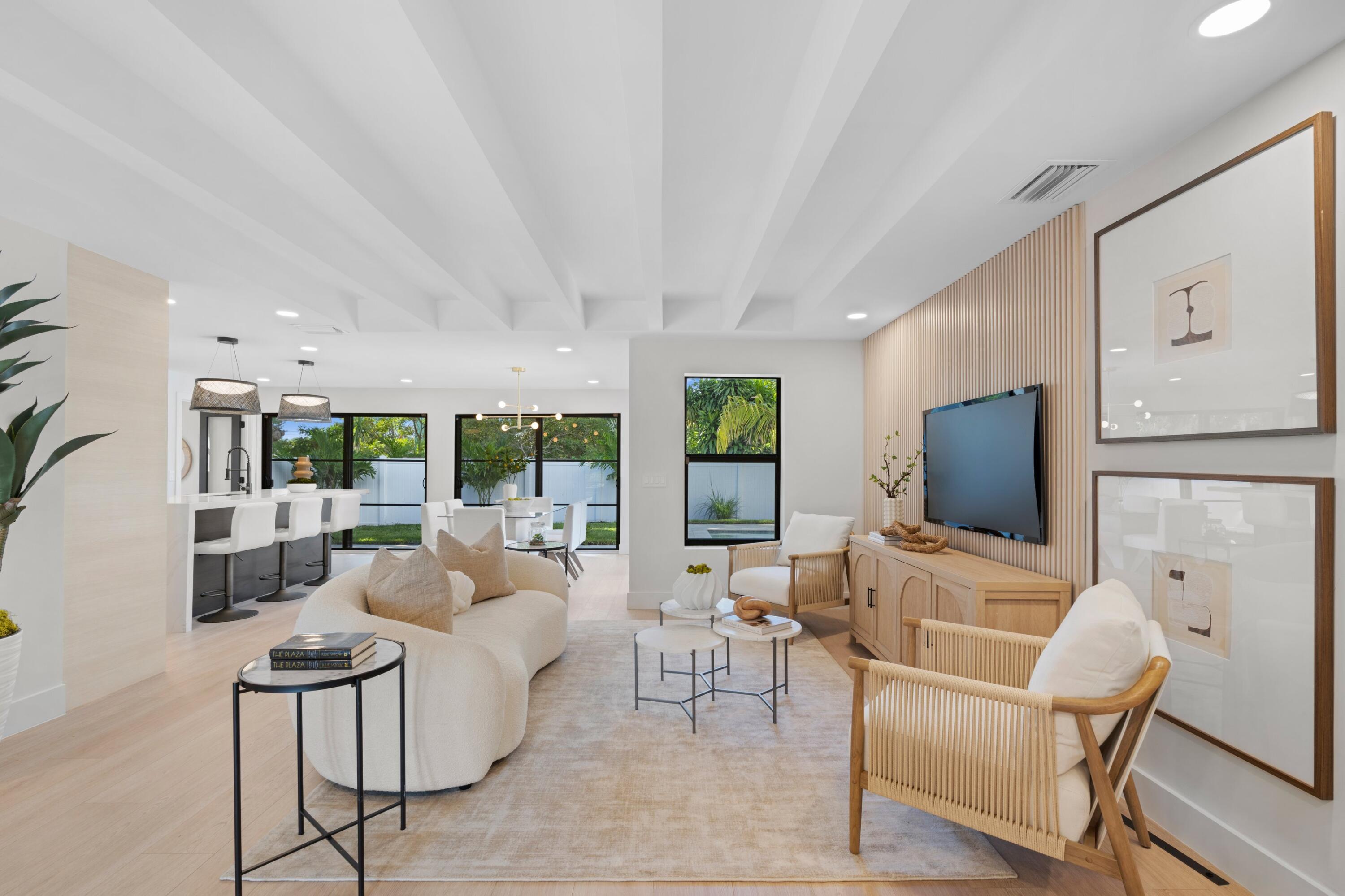 a living room with furniture a large window and a flat screen tv