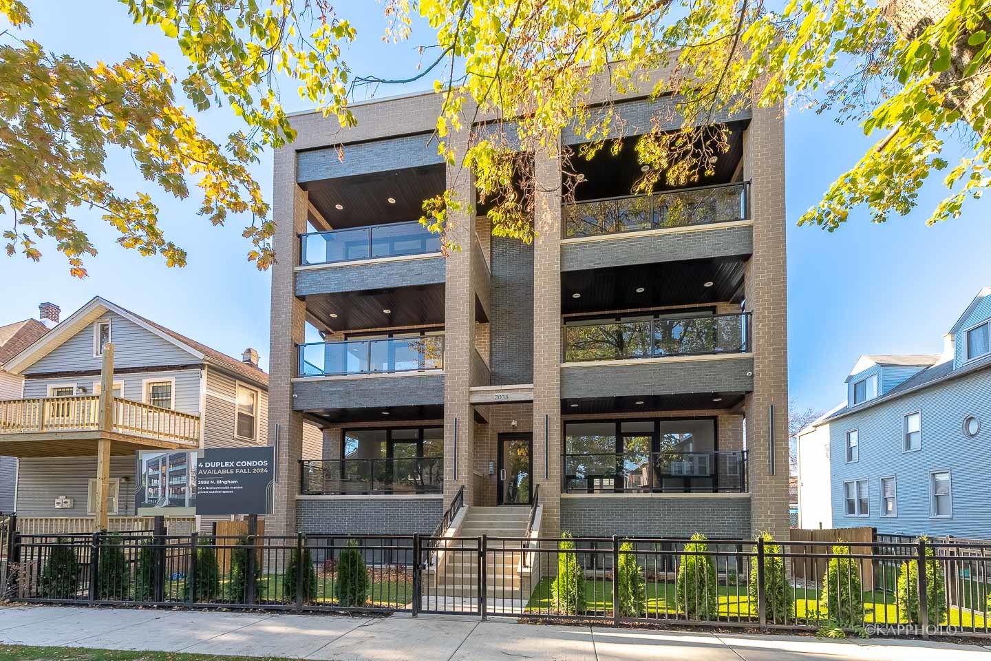 a front view of a residential apartment building with a yard