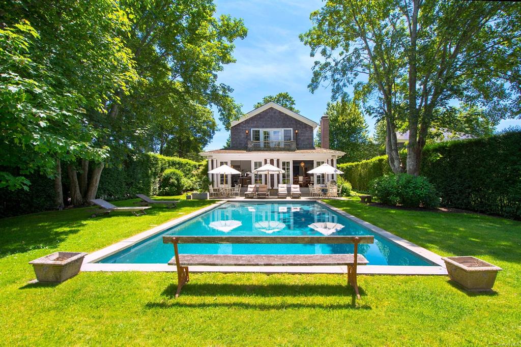 View of swimming pool featuring a lawn and a deck