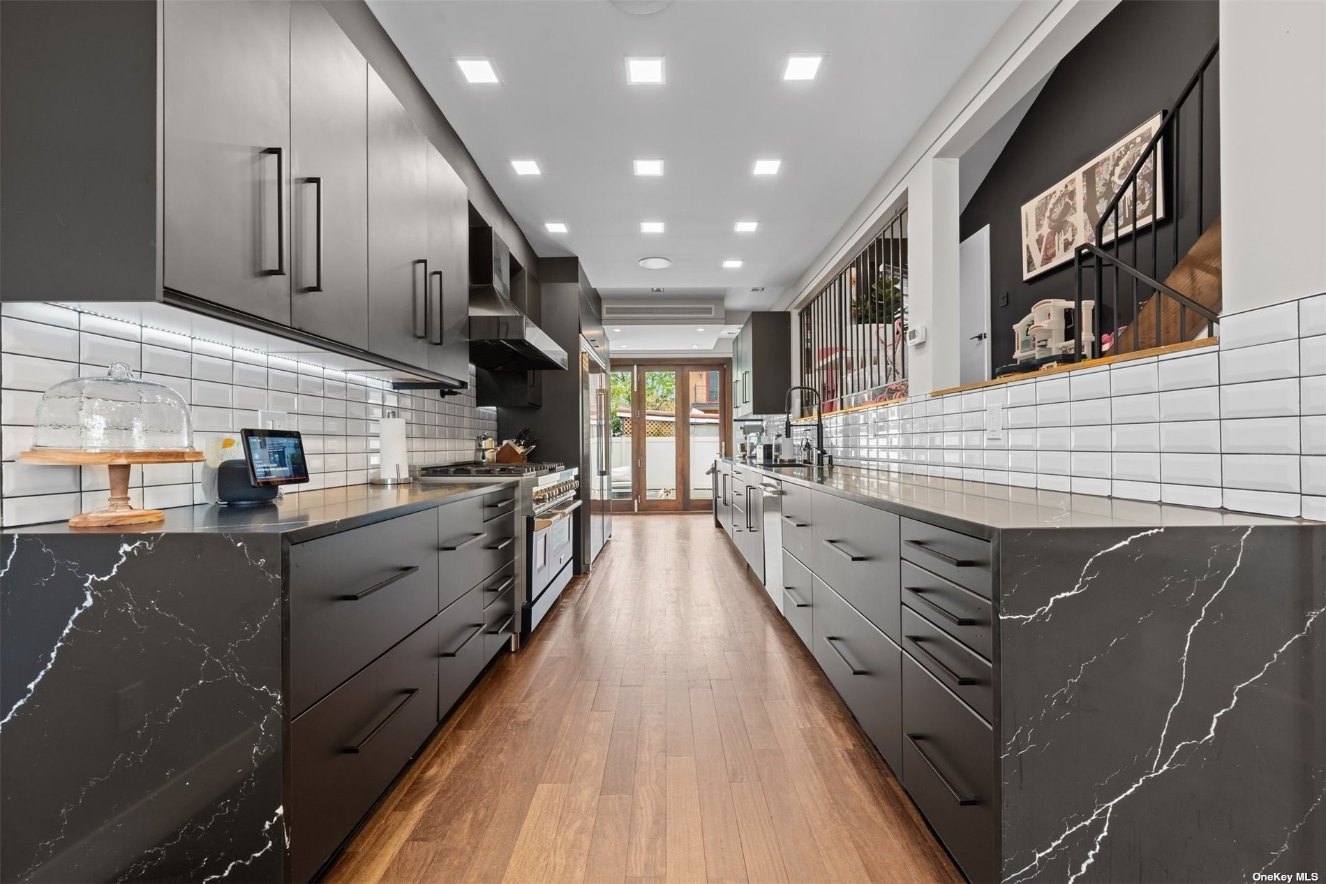 a kitchen with kitchen island wooden floors granite counter tops and white appliances