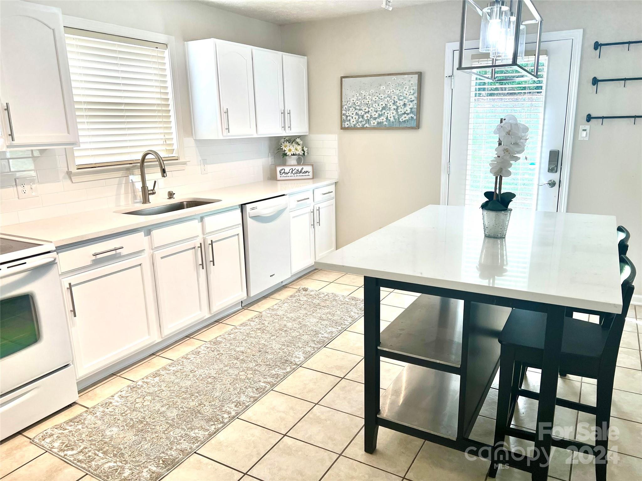 a kitchen with a table chairs sink and cabinets