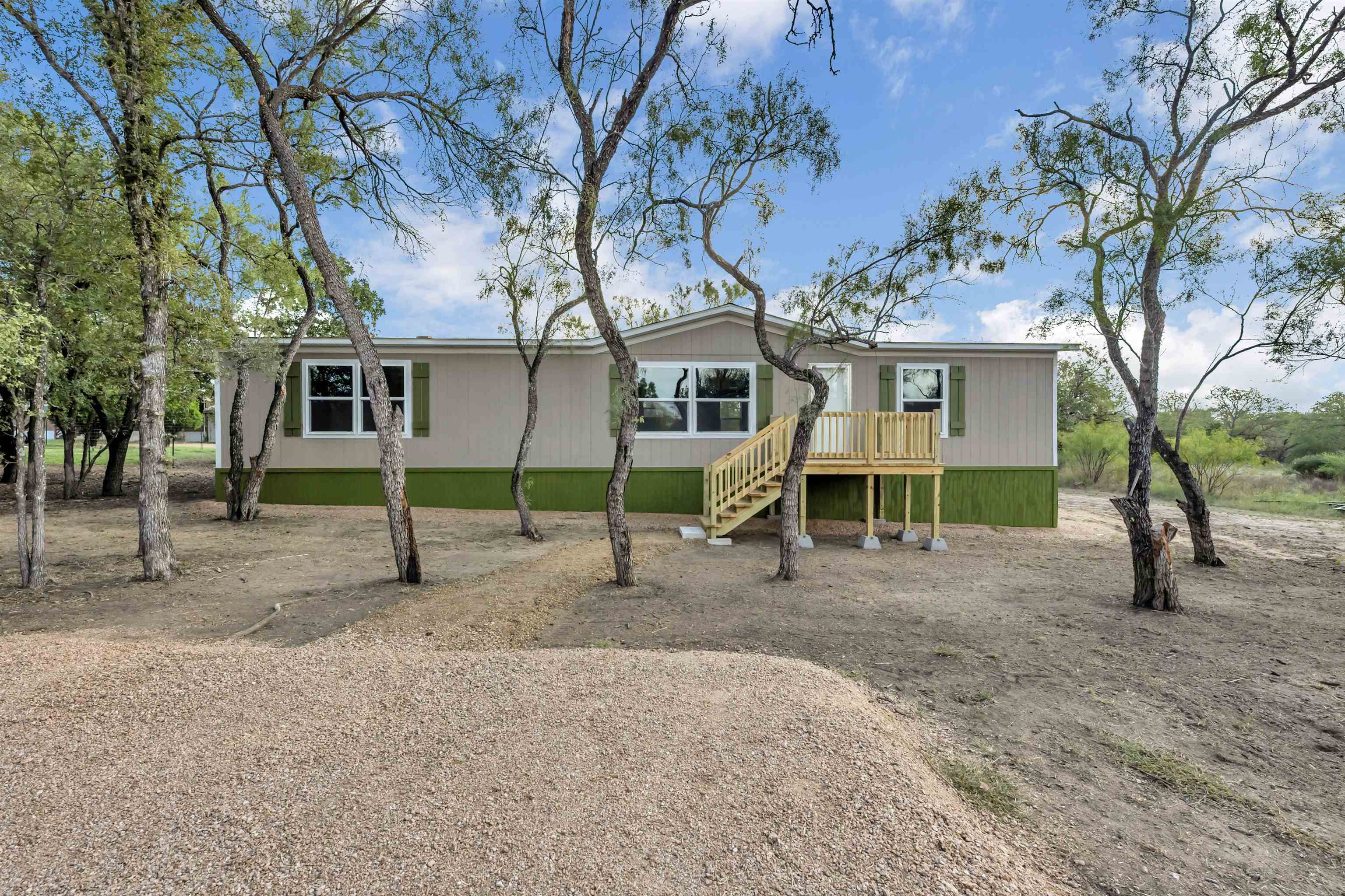 a view of a house with a backyard and tree