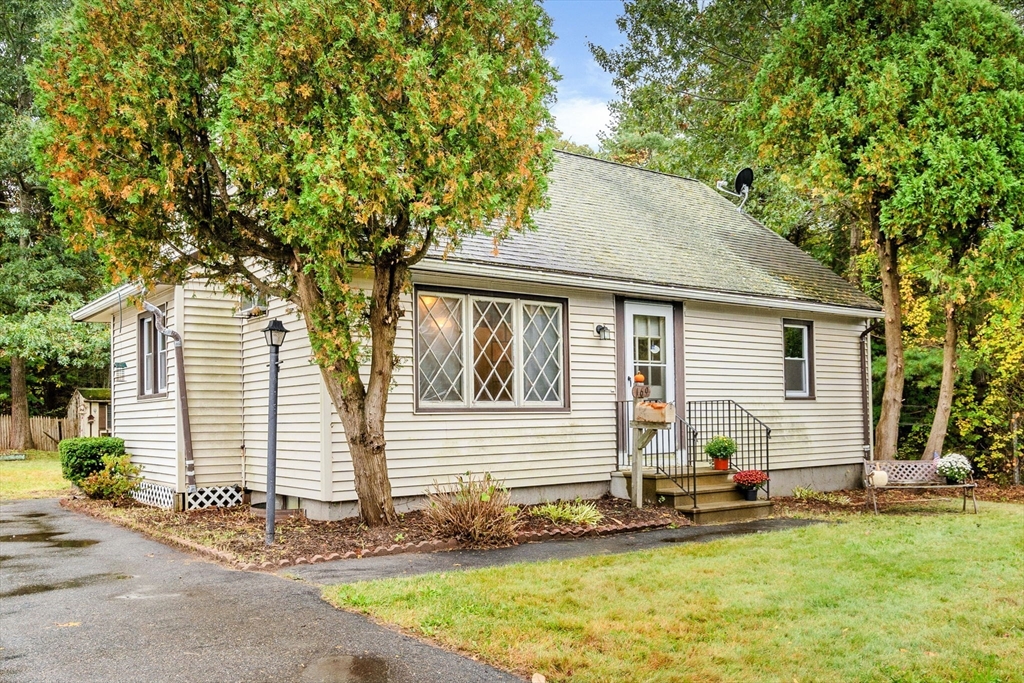 a view of a white house with a yard and sitting space