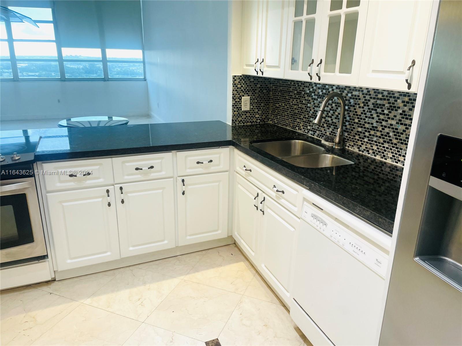 a kitchen with granite countertop white cabinets and white appliances