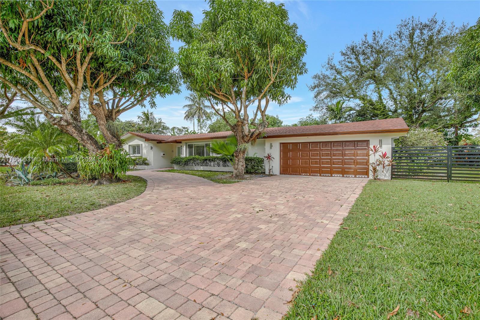 front view of a house with a yard and an trees